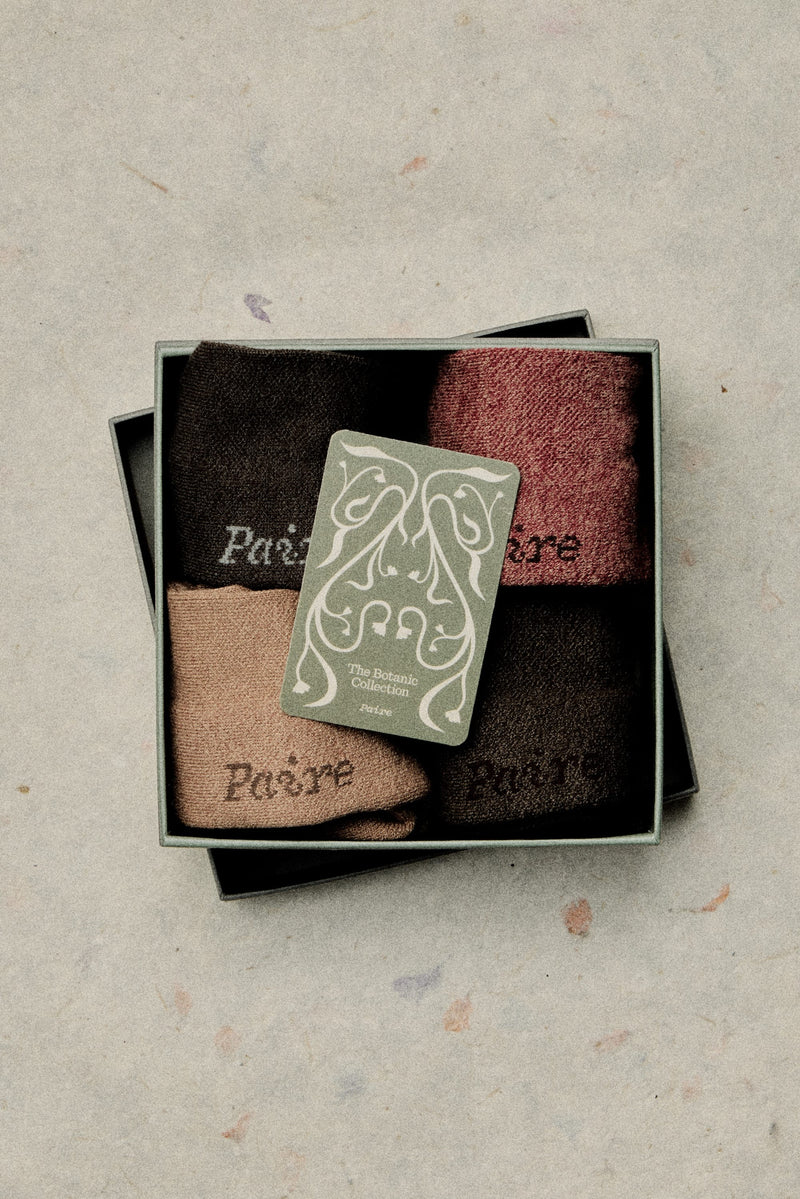 Botanic print sock gift box styled on a stone surface